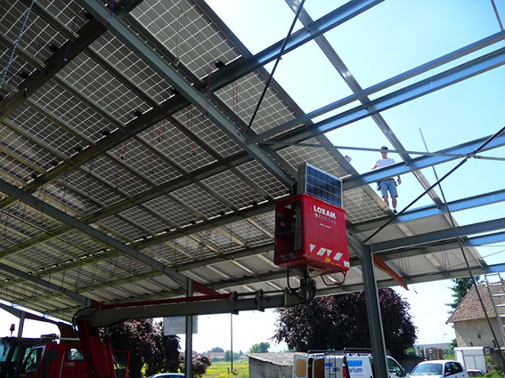 Chantier photovoltaïque, installation de modules sur le toit d'un hangar professionnel
